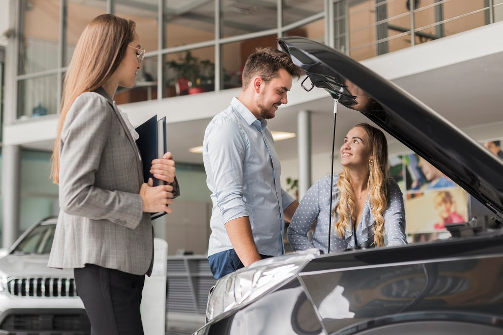 couple-checking-car-engine-showroom